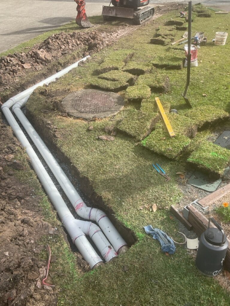 Underground drainage pipes laid in a residential lawn trench during an urgent callout by an emergency plumber in Ipswich